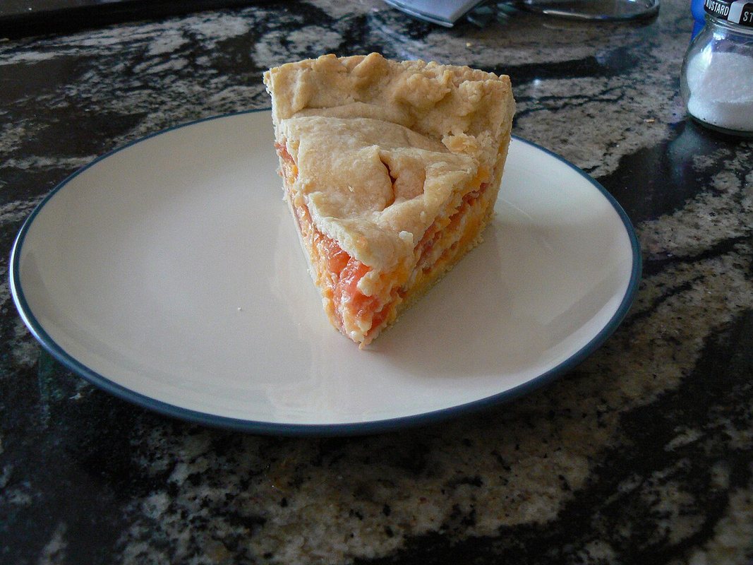 Pite me djathë dhe domate e servirur në tryezë