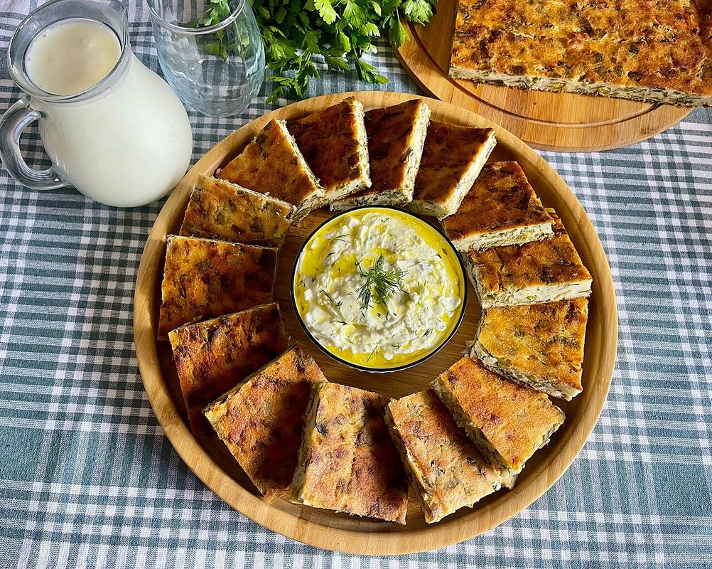 Pite me qengj dhe spinaq e servirur në tryezë