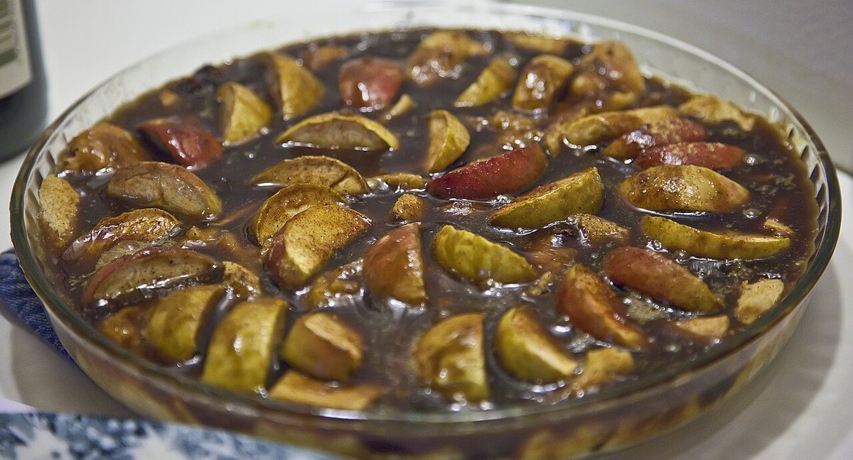 Puding me bukë dhe mollë e servirur në tryezë