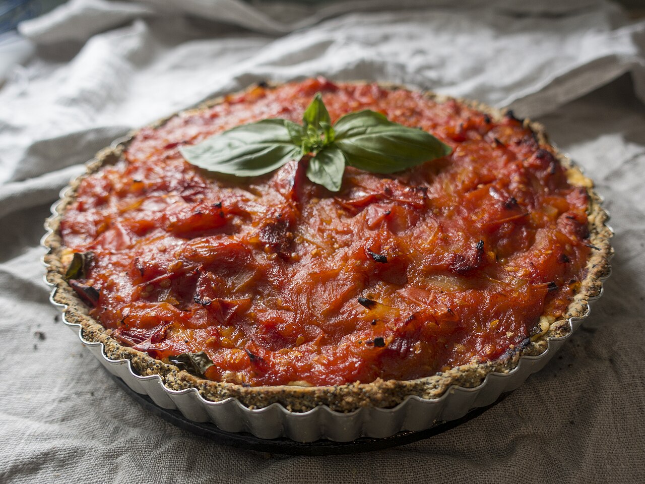 Pite me djathë dhe domate e servirur në tryezë