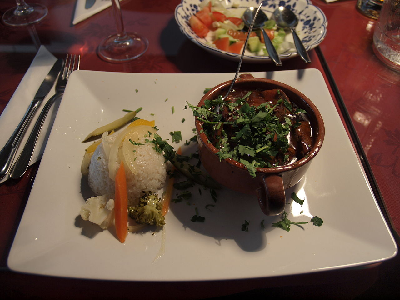 Tavë qengji me fasule e servirur në tryezë