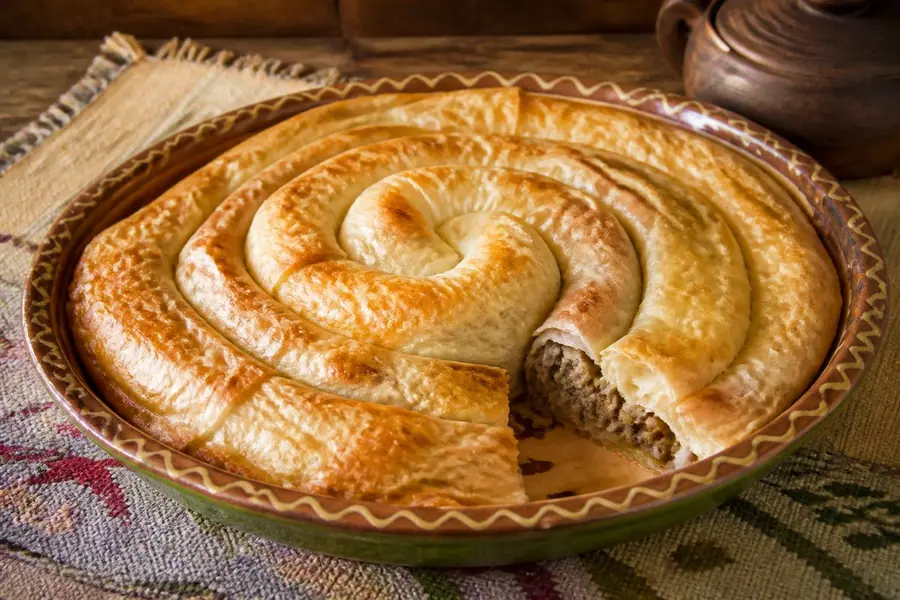 Byrek role me mish qengji e servirur në tryezë