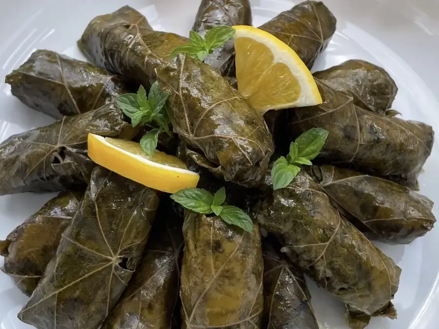 Japrakë tradicionalë me gjethe hardhie e servirur në tryezë