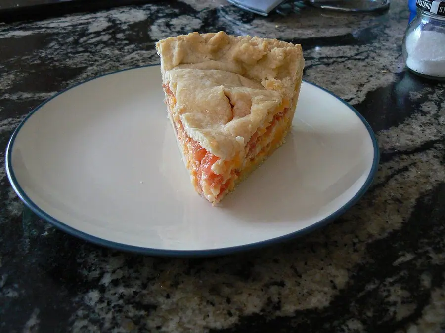 Pite me djathë dhe domate e servirur në tryezë
