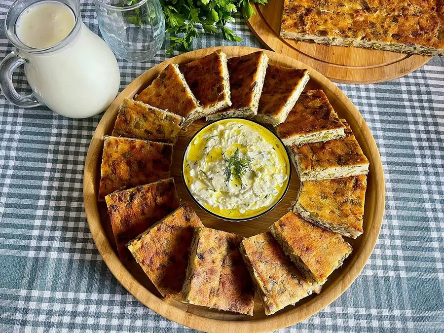 Pite me qengj dhe spinaq e servirur në tryezë