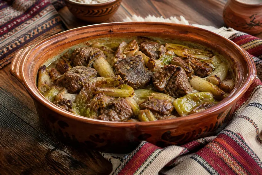 Tavë qengji me presh e servirur në tryezë